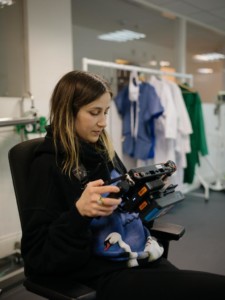 Artist Nastja Säde Rönkkö sitting on a chair, looking at the monitor